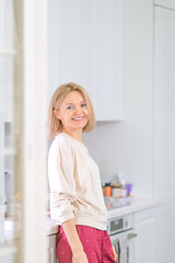 Young beautiful blonde girl at home in the kitchen
