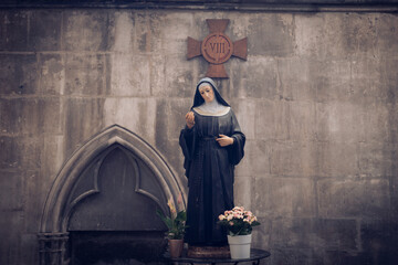 Fototapeta na wymiar Statue of Nun on table in gothic church