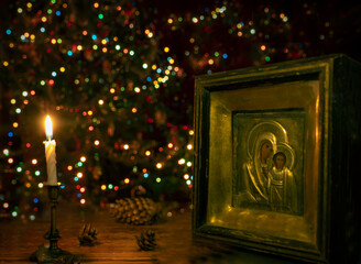 The icon of the Mother of God with the Christ Child is illuminated by a burning candle