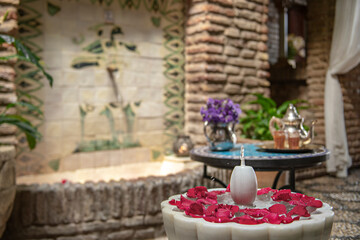 white marble fountain with rose petals and tea service
