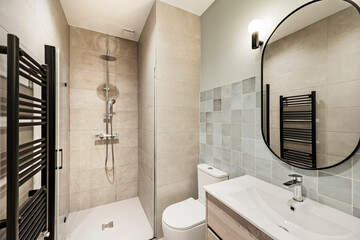 Modern toilet with shower, black towel radiator and sink