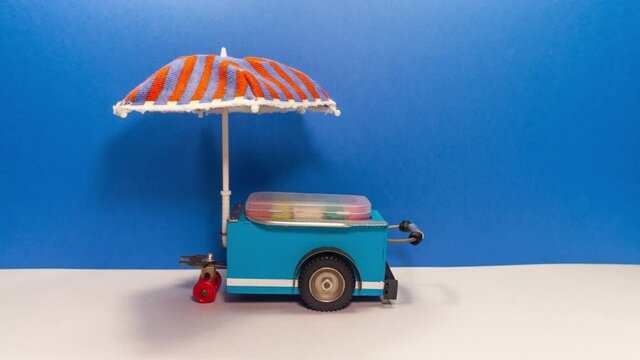 Mini shop Ice cream cart with blue red umbrella. Assortment of ice cream empty menu black chalkboard. Summer vacation concept. blue wall background.