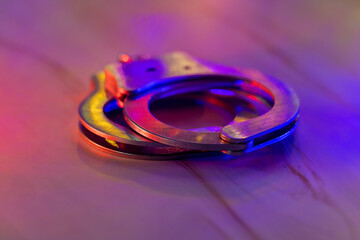 Police raid at night and you are under arrest of handcuffs with police with the flashing red and...