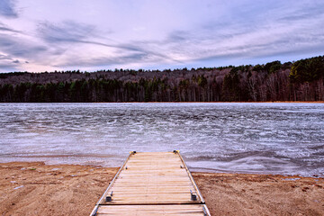 Winter at Bowman Lake State Park in Chenango County in Upstate NY.  Dock looks out over a frozen...