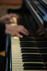 Fototapeta na wymiar Pianist's hands in close-up while playing the piano. Piano keys during a classical music concert.