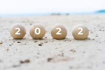 2022 on wood ball on the beach. travel on Happy New Year. relaxing vacation. Good life and new...