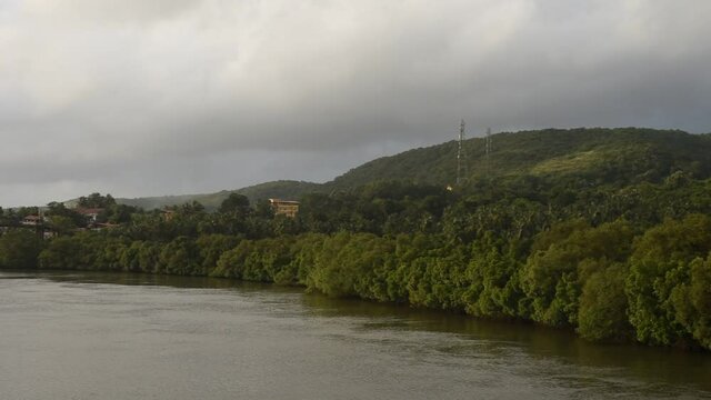 HD scenery of the Zuari river flowing through Borim village in Goa India with a view of a shipbuilding company and Borim Bridge