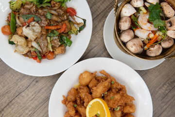 Overhead view of restaurant Thai food variety of choices with the orange chicken looking the most tempting of all