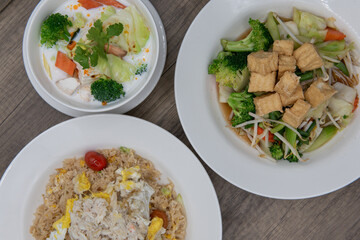 Overhead view of restaurant Thai food variety of choices with the plate of mixed vegetables under tofu looking the most tempting of all