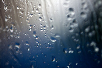Abstract background with rain drops and snowflakes on car window, wet glass, rainy day.