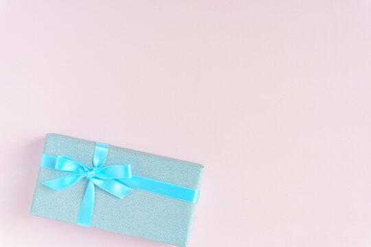 ブルーのキラキラのラッピングのプレゼント　ピンク背景