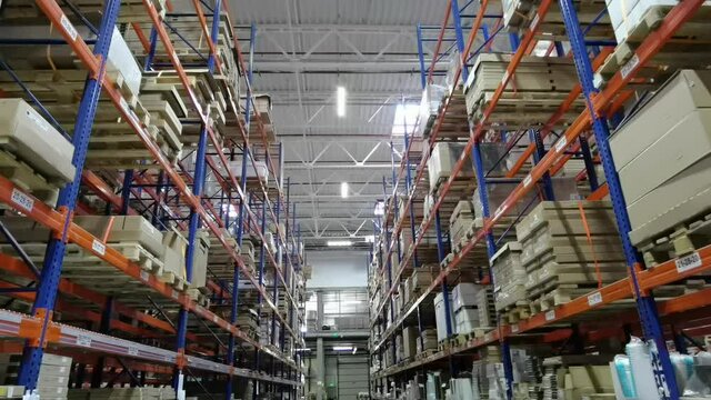 Huge distribution warehouse with high shelves and loaders.