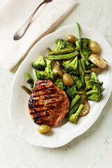 Grilled Turkey Breast with oven baked potatoes and broccoli. Bright  wooden background. Top view. 