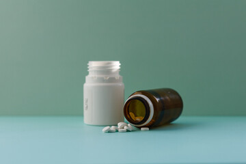 Fototapeta White pills (medicine) spilling out of a brown bottle obraz