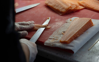 red fish two knives cutting board chef's hands