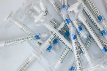 Insulin syringes without plastic needles lie on a white background, medical waste