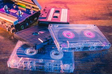 Old vintage audio cassettes on wooden surface. Retro music format of the eighties. Colorful analog...