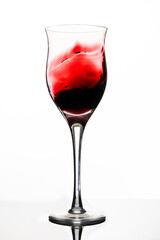 Swirl or movement of liquid in a glass of red wine. White background, vertical orientation. Concept of movement, elegance.