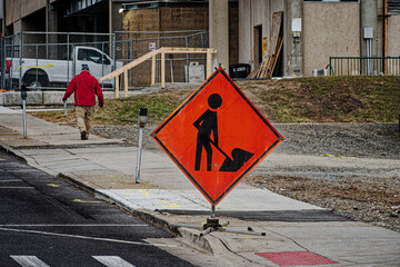 A gentleman walks past the Construction Warning sign and into the work zone.  