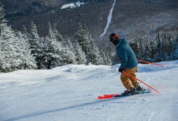 Man skier skiing down the slope. Extreme winter sport. Stowe Mountain Resort, Vermont.