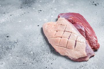 Duck breast fillet on butcher table, raw poultry meat. Gray background. Top view. Copy space