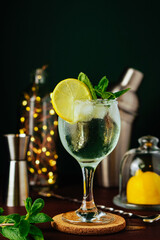Fresh Mojito cocktail with lemon, mint and ice in jar glass on dark blue background. Summer cocktail