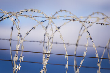 Closeup focus view of NATO barb wire with sharp and dangerous razor blades	