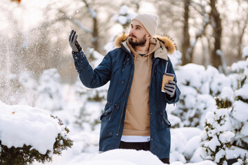 Handsome bearded young  man standing outdoors fur hood in winter season forest. Season holiday leisure. Nature.