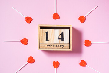 Empty picture frame and wooden date calendar with two red ribbons on purple background. Creative and cool celebration of love concept
