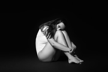 Obraz premium Scared young woman on dark background. Violence concept