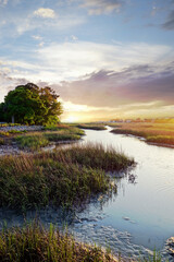 Coastal homes in the distance along the marsh waterways in the Low Country near Charleston SC at sunset