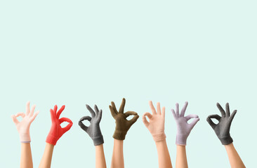 Women in warm gloves showing OK gesture on blue background