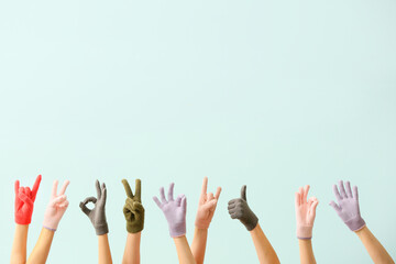 Women in warm gloves showing different gestures on blue background