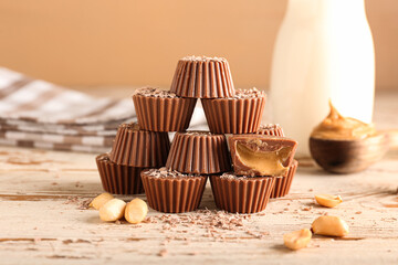 Tasty chocolate candies with peanut butter on wooden background