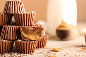Tasty chocolate candies with peanut butter on wooden background, closeup