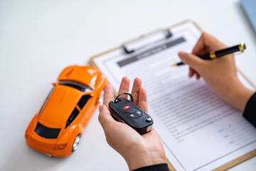 Insurance officers hand over the car keys after the tenant. have signed an auto insurance document...