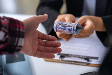 Fototapeta premium two businessmen handing each other money After a successful business agreement is mutually agreed upon.
