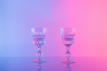 Two glasses for drink a color neon background. Minimal concept.