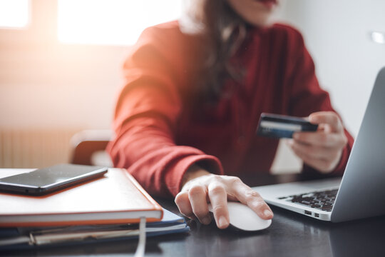 Close up woman's hand using credit card and laptop for smartphones to buy online shopping - Powered by Adobe