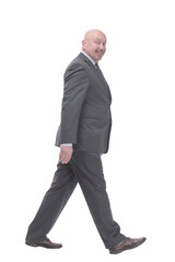 Mature business man striding forward .isolated on a white background.