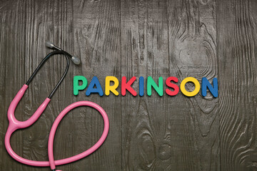 Word PARKINSON with stethoscope on wooden background