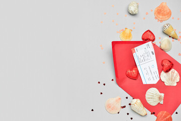 Envelope with tickets, hearts, confetti and seashells on light background. Valentine's Day...