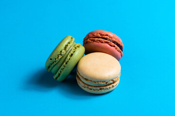 Colorful cake macaron or macaroon on blue background. Flat lay, top view, copy space