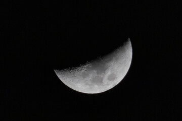 Closeup photo of moon on blue sky. Realistic photo of half moon.