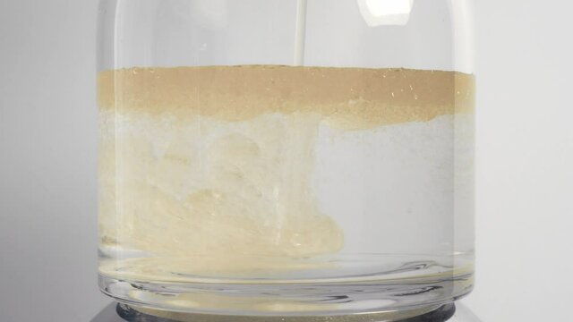 Oil and honey poured into water separate into different density layers