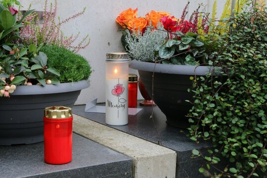 Allerheiligen an einem Friedhof in Österreich, herbstliche Grabgestaltung eines Familiengrabes zu Allerheiligen mit Gedenkkerzen, Herbstblumen und Rosen