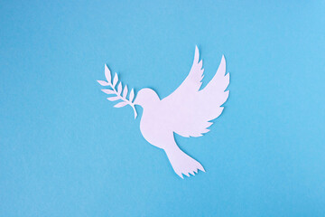 A white dove cut out of paper for the background of the World Peace Day. World Science Day for Peace and Development - obrazy, fototapety, plakaty
