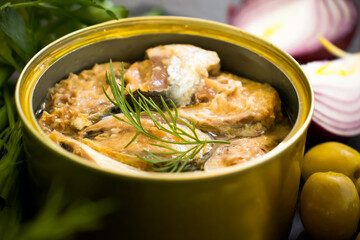 canned fish in a jar, dill on a wooden background