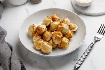 Fried dumplings on a white plate. Russian dish. Dumplings. On a white plate and a white background