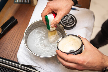 hands of hairdresser with beard shaving brush and bowl. Hairdresser's. Preparation before shaving